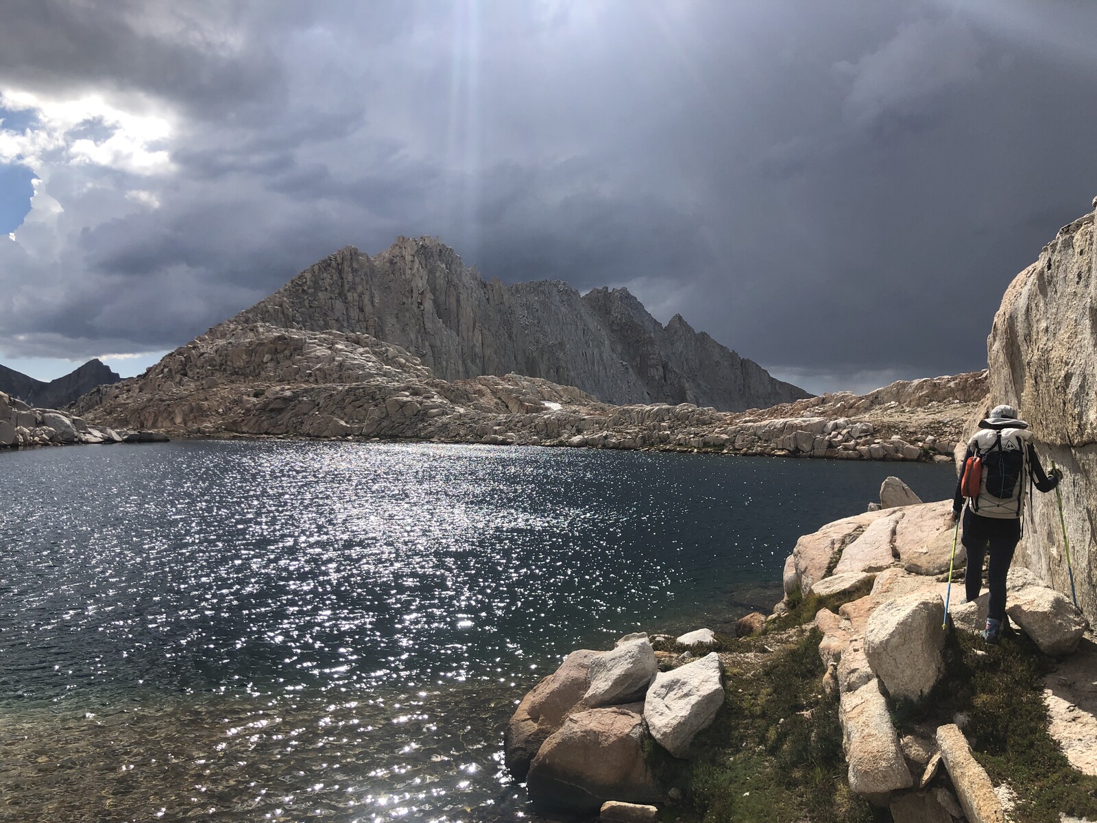 Stormy clouds above alpine lake with dramatic rock formations